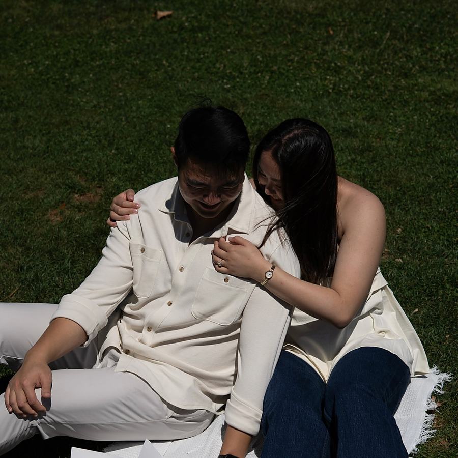 Ashley and Benjamin laughing together on the grass
